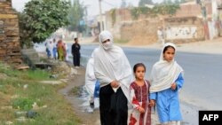 Девочки возвращаются вместе с матерью домой после уроков в школе. Долина Сват, 9 октября 2013 года.