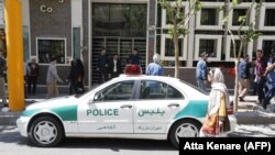 Një veturë e policisë iraniane e parkuar para një dyqani të këmbimit të monedhave në Teheran. 10 prill, 2018