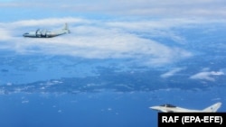 Egy orosz Antonov AN–12-es repülőgép (fent) és a Brit Királyi Légierő (RAF) Typhoon repülőgépe (lent) az észt légtérhez közeli elfogás közben, 2019. június 25-én