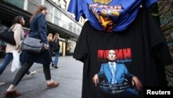Луѓе поминуваат покрај маици со портрети на рускиот претседател Владимир Путин, изложени на продажба на улица во Белград, 11 април 2017 година