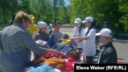 Люди, пришедшие на ярмарку для малоимущих семей, рассматривают вещи. Темиртау, 29 мая 2013 года.