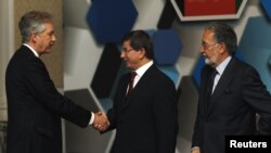 Turkish Foreign Minister Ahmet Davutoglu (center), accompanied by his Afghan counterpart Zalmay Rasul (right), shakes hands with U.S. Deputy Secretary of State William Burns before the Istanbul Conference on November 2.