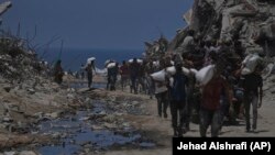 Palestinci nose vreće sa brašnom istovrene za humanitarnog konvoja koji je stigao u Gazu 22. jula 2025. usred raširene nestašice hrane