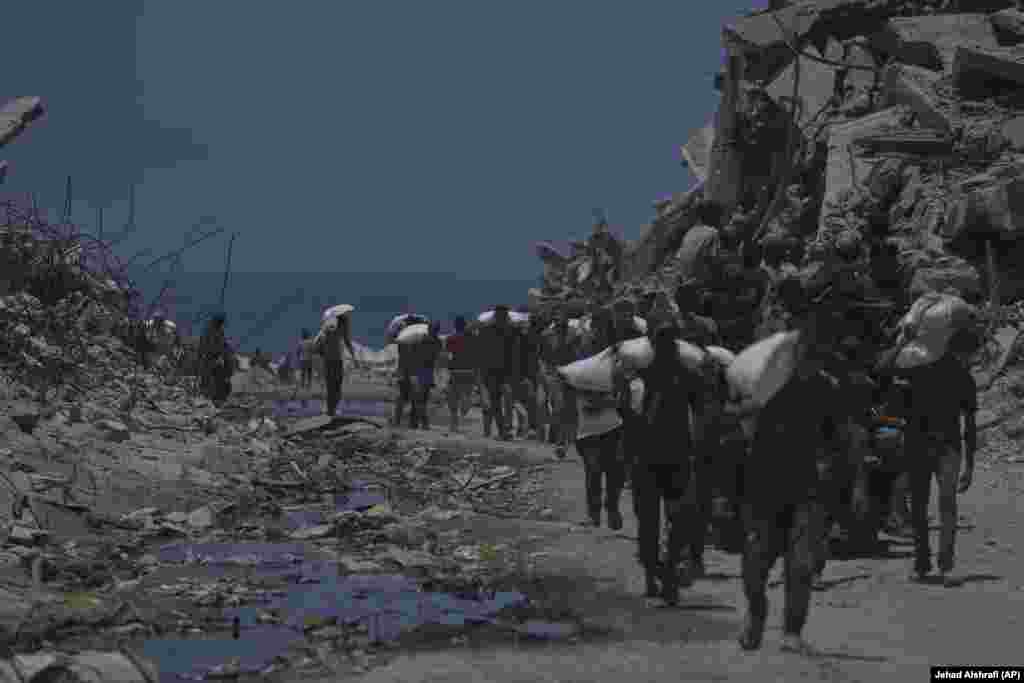 Palestinezë të tjerë duke bartur thasë me miell, më 22 korrik.