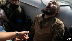 A Ukrainian soldier reacts as he receives an injection during an evacuation of injured soldiers in a region near the retaken village of Shchurove on September 25.