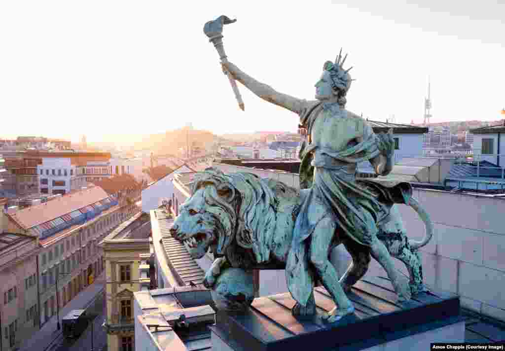 Nosač svetla i lav, koje je 1898. godine dovršio vajar Antonin Pop, a koji su postavljeni na krov Češke narodne banke. Godine 2019. postavljena je vremenska kapsula unutar spomenika na stotu godišnjicu uspostavljanja valute Čehoslovačke, krune. Vremenska kapsula treba da bude otvorena 2069. godine. &nbsp;