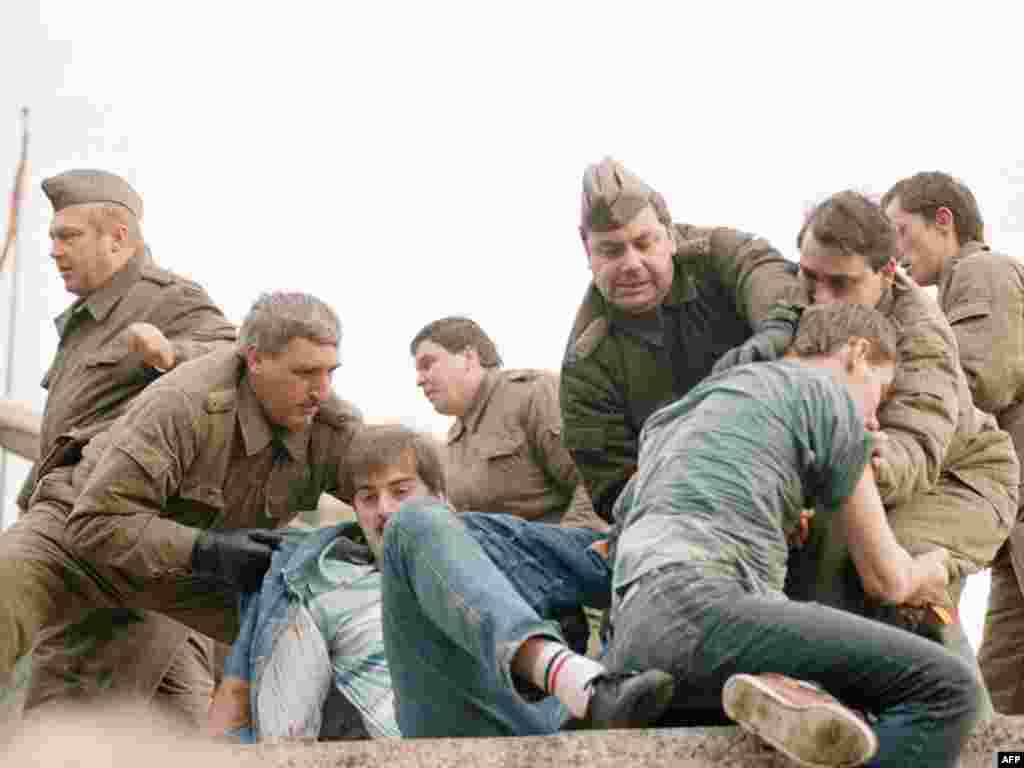 Komešanje civila i policajaca Istočne Njemačke nakon što su se pojedinci popeli na Berlinski zid kod Trga Potsdamer, 11. novembar 1989. 