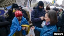 აშშ-ის სახელმწიფო მდივნის მოადგილე ვიქტორია ნურლანდი ბუტერბროდებს ურიგებს დემონსტრანტებს და პოლიციელებს კიევში