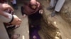 FILE: Afghan women activists weep and lie in the grave of Afghan woman Farkhunda, 27, who was lynched by an angry mob in Kabul in March 2015.