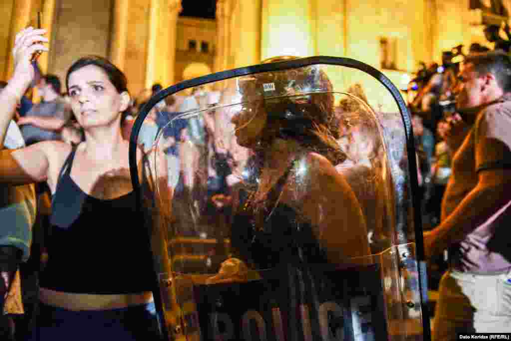 Demonstranti sa policijskim štitovima.