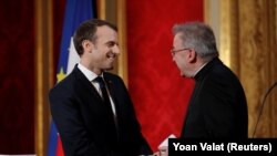 Emmanuel Macron francia elnök (b) üdvözli Luigi Ventura akkori pápai nunciust a párizsi Élysée-palotában 2018. január 4-én.