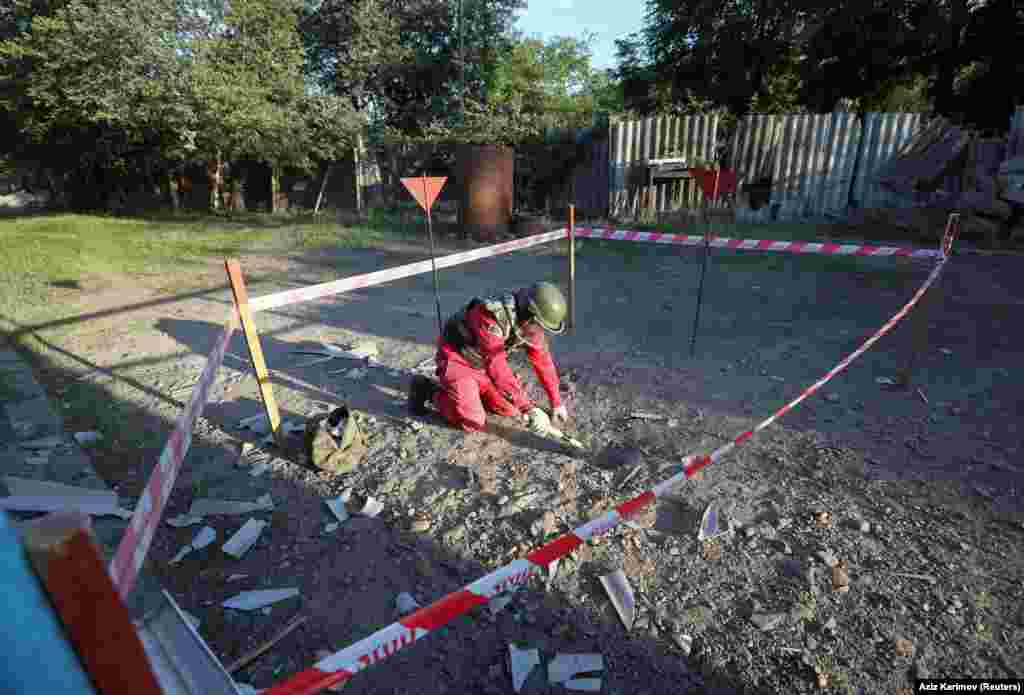 Deminer u zaštitnoj opremi radi na neeksplodiranoj granati pored kuće u azerbejdžanskom selu Agdam. Nekoliko sela s obje strane armensko-azerbejdžanske granice granatirano je. (15. juli)