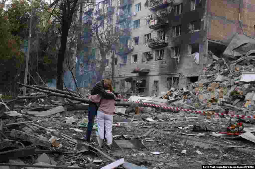 Мъж и жена се прегръщат сред развалините в украинската столица.Руските удари поразиха и градовете Запорожие и Одеса, където има един загинал човек.