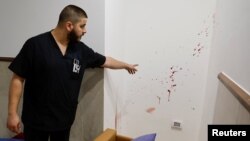Un bărbat arată urmele împușcării a trei palestinieni într-un spital din Jenin (Cisiordania ocupată) la 30 ianuarie 2024. Hamas a recunoscut că erau membrii săi, iar Israelul a spus că ar fi pus la cale un atac iminent. 