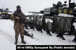 Украинский военнослужащий возле разбитой под Харьковом в начале марта 2022 года колонны военной техники 200-й мотострелковой бригады