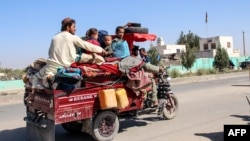 Residents flee Nadali district to Helmand's provincial capital, Lashkar Gah, during the ongoing clashes between Taliban fighters and Afghan security forces on October 14.
