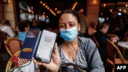 Посетителка на заведение в Довил, Франция, показва своя здравен пропуск