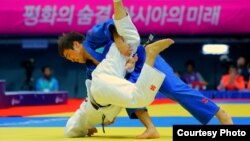 Казахстанский дзюдоист Елдос Сметов (в голубом) в финале на Азиатских играх в Южной Корее. 20 сентября 2014 года.