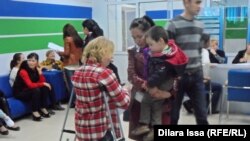 Безработные оставляют резюме и получают брошюры от потенциального работодателя на ярмарке вакансий в Шымкенте. 18 апреля 2015 года. Иллюстративное фото.