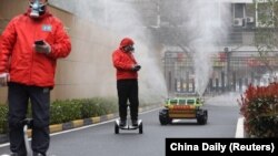 Radnici kontorlišu robote koji sprovode dezinfekciju Vuhana, 3. mart 2020. 