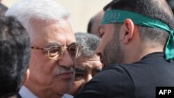 Palestinian President Mahmud Abbas (left) welcomes a prisoner wearing a Hamas headband following the release of hundreds of prisoners from Israeli jails in October.