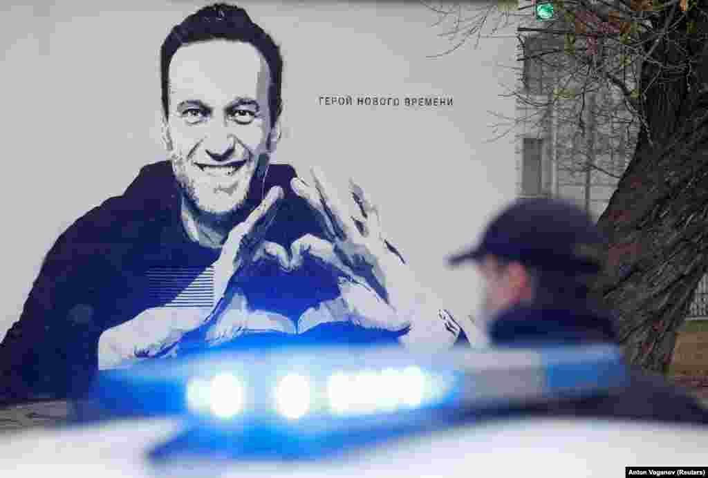 Egy rendőr egy Navalnijról készült graffiti előtt 2021 áprilisában Szentpétervárott. Navalnijt januárban vették őrizetbe, később pedig politikai irodáinak és Korrupcióellenes Alapítványának (FBK) országos hálózatát szélsőségesnek nyilvánították és betiltották