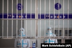 Védőruhás biztonsági tisztek az Urumcsi 3. számú fogolytábor látogatóterme előtt 2021. április 23-án