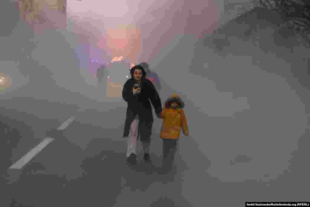 Мать уводит ребенка из района, пострадавшего при российском авиаударе. Киев, 20 декабря 2024 года.