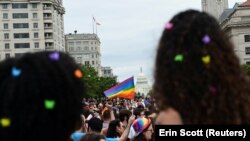 Háttérben a Capitolium épülete egy LMBTQ+ Pride-felvonuláson Washingtonban, az Egyesült Államokban 2021. június 12-én