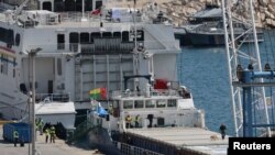 Policajac koristi psa tragača da pregleda teretni brod natovaren humanitarnom pomoći za Gazu, u luci Larnaka, Kipar, 16. marta 2024. 