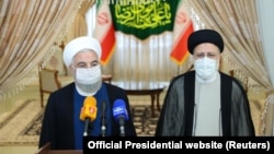 Dosadašnji iranski predsjednik Hasan Rohani (lijevo) i njegov nasljednik Ebrahim Raisi u prvom obraćanju medijima nakon izbora, Teheran (19. juni 2021.)