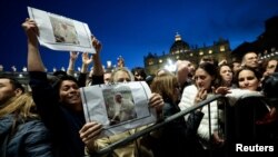 Хора на площад "Свети Петър" в Рим държат снимки на папа Франциск