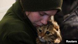 Medicinska sestra Katerina, evakuisana iz grada Kostjantinovke na istočnoj liniji fronta, tješi svoju mačku Abu u tranzitnom centru u Pavlogradu, Dnjepropetrovska oblast, Ukrajina, 31. mart 2025. 