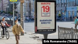 Muškarac prolazi pored predizbornog plakata postavljenog uoči parlamentarnih izbora u Rusiji zakazanih za 17. i 19. septembar