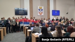 Opozicioni odbornici drže zastavu Srbije i intoniraju himnu na sednici Skupštine Grada Beograda, 6. mart 2025.