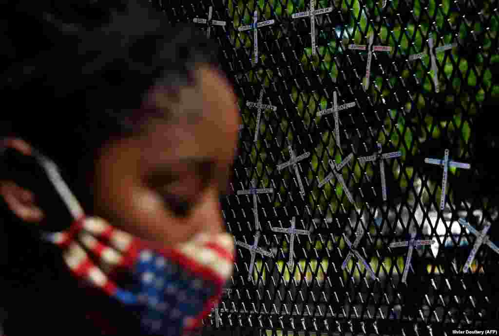 Демонстрант пред ѕидот на кој се прикажани имиња на црнци кои биле убиени од полицијата, во близина на Белата куќа за време на мирниот протест против полициската бруталност и смртта на Џорџ Флојд, на 7 јуни 2020 година во Вашингтон.