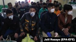 Afghans returning from Iran wait to be screened for the coronavirus on the Islam Qala border crossing in the western province of Herat on March 22.