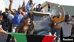 Libijski pobunjenici sa kolima za golf koja su pripadala Moameru Gadafiju, 23. avgust 2011.