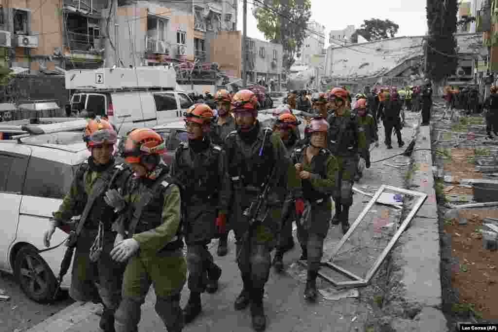 Ushtarë izraelitë duke mbërritur në vendin ku goditi një raketë iraniane, në Bnei Brak, afër Tel Avivit, më 16 qershor.