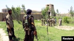 FILE: An anti-Taliban militia fighters look at the Afghan policemen as they prepare to battle the Taliban.
