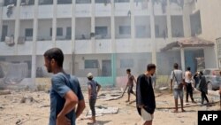 Палестинци оглеждат щетите след израелската атака срещу училището. 