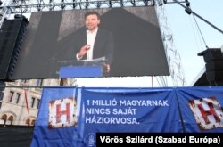 Álmos Péter, a Magyar Orvosi Kamara elnöke felszólal a Parlament előtti tiltakozáson, amelyen az egészségügyi rendszer reformját követelték. A molinó szerint egymillió magyarnak nincs saját háziorvosa. Budapest, 2025. március 8-án