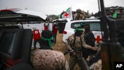 Luptătorii Hamas predau Crucii Roșii, joi, la Khan Younis, în sudul Fâșiei Gaza, sicriele în care se aflau trupurile a patru ostatici israelieni, inclusiv o mamă și cei doi copii ai săi.