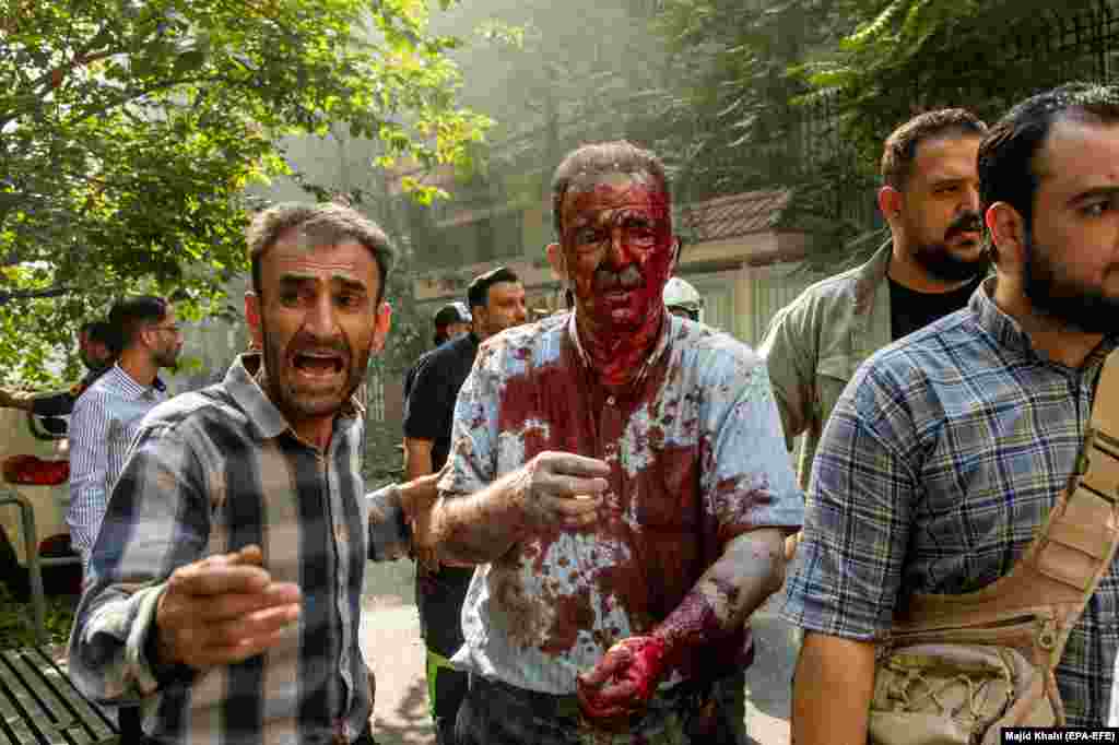 People help a wounded man following an Israeli strike on central Tehran on June 15.
