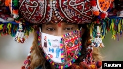 Një indiane me maskë teksa merr pjesë në një festë tradicionale.