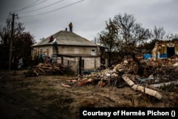 Eddy (lent balra) és társai egy donyecki településen javítanak egy, a háborúban megrongálódott háztetőt 2024. november 6-án