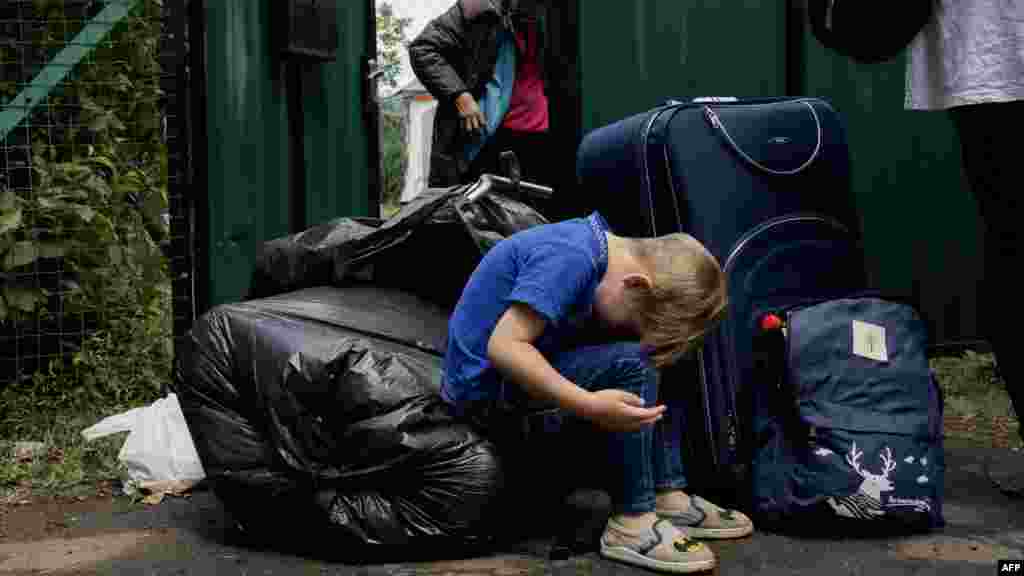 Ez a család kihordta holmiját házuk elé, így várják a buszt, amelyen majd elhagyhatják a Dnyipropetrovszki területet