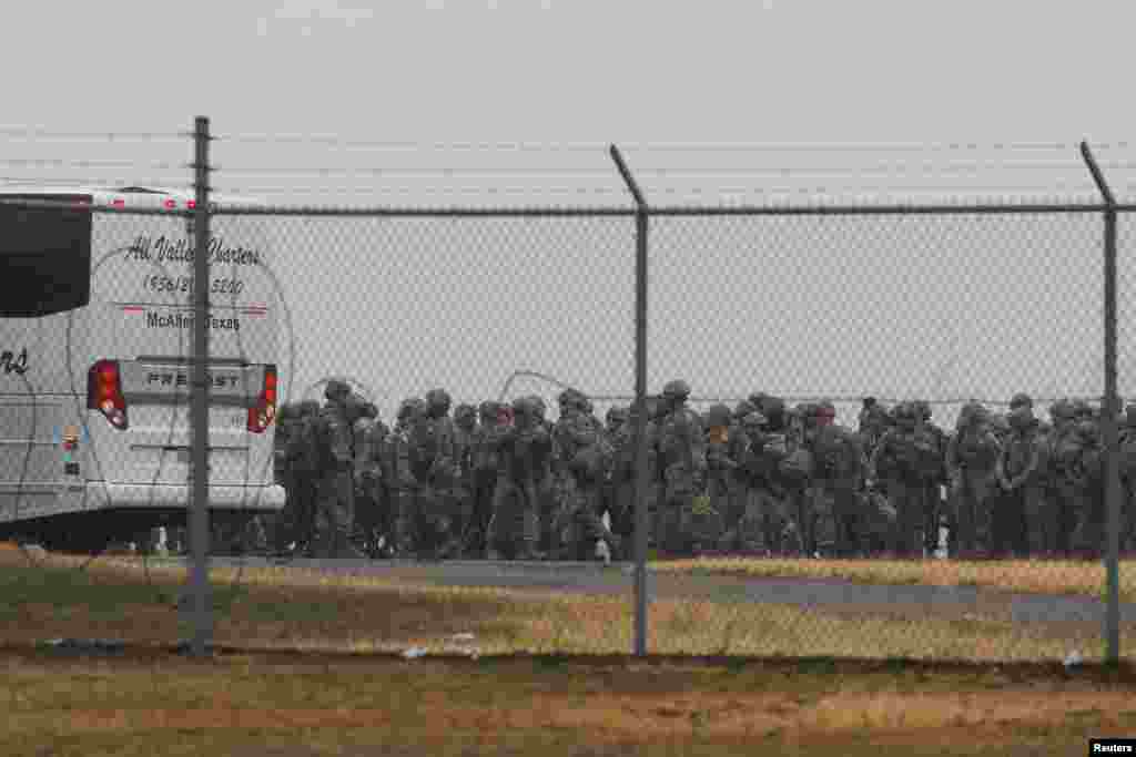 Anëtarët e Gardës Kombëtare të Teksasit ecin në radhë për të hipur në një autobus pasi mbërritën në Aeroportin Ndërkombëtar të MekAllenit, për të ndihmuar në sigurinë përgjatë kufirit me Meksikën, në Teksas, 27 janar.&nbsp;