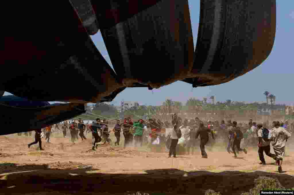 Palestinci trče prema pomoći koja je pala iz zraka u Deir Al-Balahu 18. avgusta.