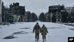 Ukrainian soldiers walk along a street lined with damaged buildings in Bakhmut, Donetsk region, on February 12.